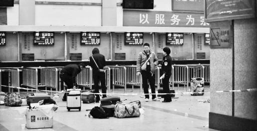Police stand near luggages left at the ticket office after a group of armed men attacked people at Kunming railway station, Yunn